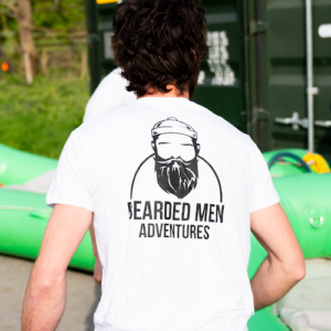 Man wearing White t-shirt with bearded men adventures logo.