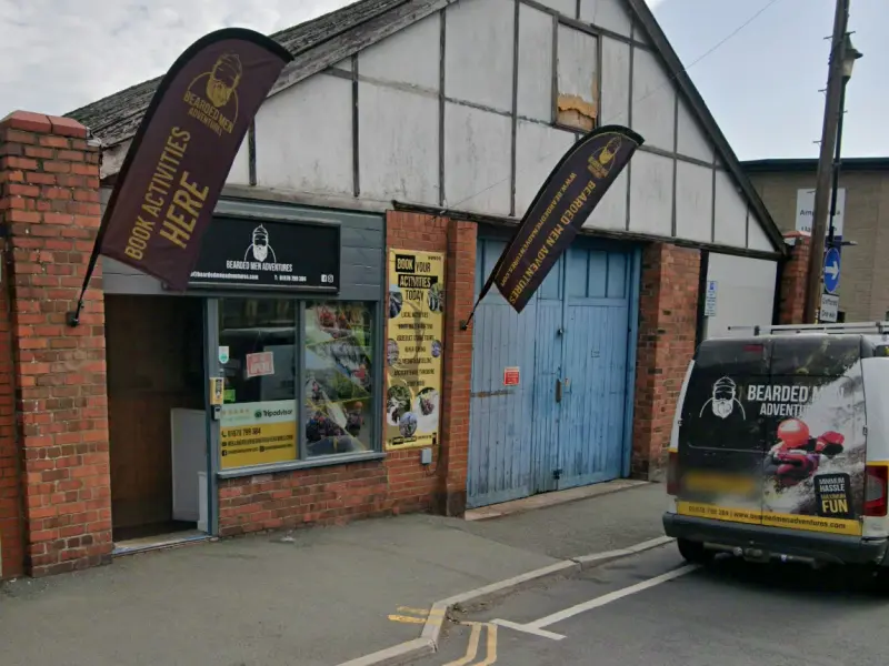 The Bearded Men Adventures office on Parade St, Llangollen: a brick shopfront with Book Activities Here flags
